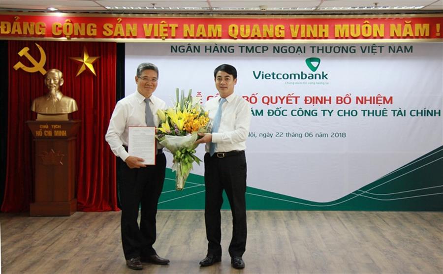 Chủ tịch HĐQT Vietcombank Nghiêm Xuân Thành (bên phải) trao Quyết định bổ nhiệm và tặng hoa chúc mừng ông Phan Dương - tân Giám đốc Công ty VCBL